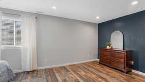 Bedroom featuring wood finished floors, recessed lighting, and baseboards