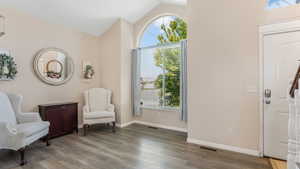 Sitting room featuring vaulted ceiling, wood finished floors, and baseboards