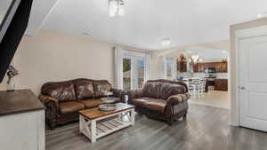 Living area with arched walkways, light wood-style floors, and a chandelier