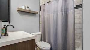 Bathroom with toilet, vanity, and shower / tub combo