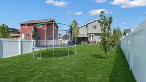 View of yard with a trampoline, a gazebo, and a residential view