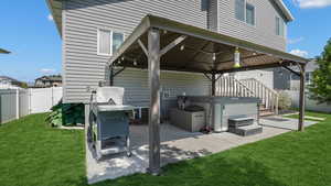 View of patio / terrace featuring a hot tub and a gazebo