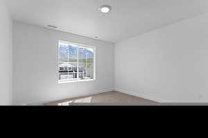 Carpeted spare room with baseboards