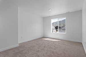 Carpeted empty room featuring baseboards and a textured ceiling