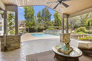 View of pool featuring a ceiling fan, a patio area, a fenced backyard, and a diving board