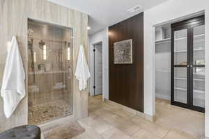 Full bathroom with a shower stall, baseboards, and tile patterned flooring