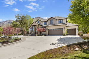 View of front of house featuring concrete driveway, board and batten siding, a mountain view, a garage, and an attached garage
