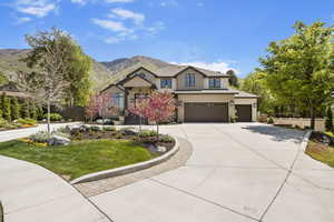 View of front of property with concrete driveway, a garage, a mountain view, and board and batten siding