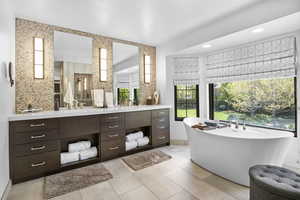 Full bath featuring vanity, a freestanding tub, and recessed lighting