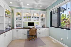 Office space with built in study area, light carpet, beam ceiling, recessed lighting, and ornamental molding