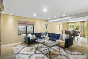 Living room featuring recessed lighting, baseboards, and a textured ceiling