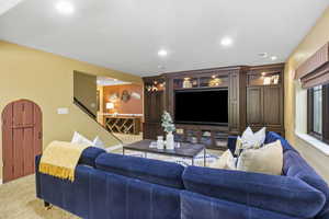 Living area featuring carpet floors, recessed lighting, and stairway