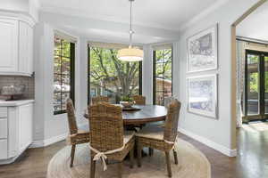 Dining room featuring baseboards, crown molding, and dark wood-type flooring