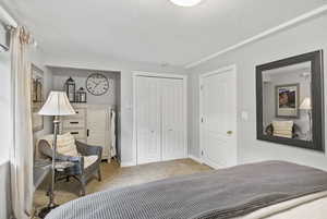 Carpeted bedroom with a closet and baseboards