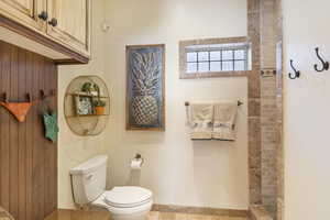 Bathroom featuring a tile shower and toilet