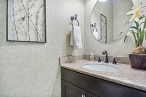Bathroom with vanity and wallpapered walls
