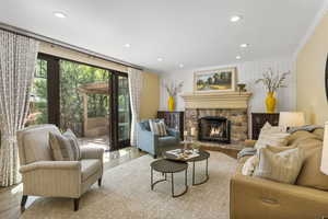 Living area featuring ornamental molding, wood finished floors, a fireplace, and recessed lighting