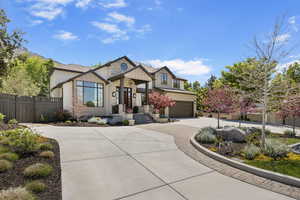 View of front facade featuring fence, concrete driveway, a garage, and board and batten siding