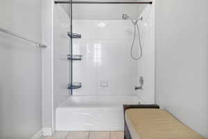 Bathroom with bathing tub / shower combination and tile patterned flooring