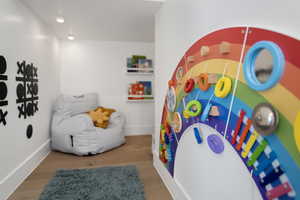 Recreation room featuring wood finished floors and baseboards