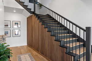 Staircase featuring hardwood / wood-style flooring, recessed lighting, wood walls, and baseboards