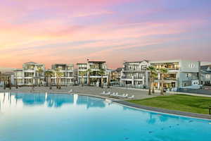 Community pool with a residential view and a lawn