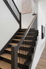 Staircase with wood finished floors and baseboards