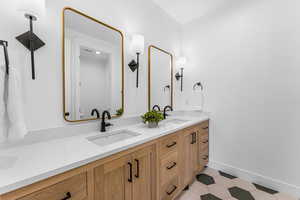 Bathroom featuring double vanity and baseboards