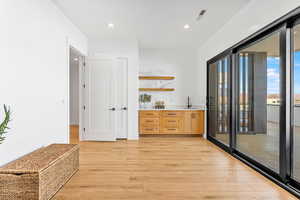 Indoor wet bar featuring light wood-style flooring and recessed lighting