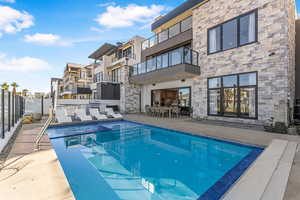 View of swimming pool with fence, a patio, and a residential view