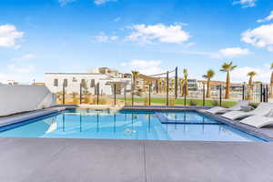 View of pool featuring a residential view, a pool with connected hot tub, and fence