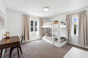 Carpeted bedroom featuring an office area