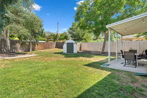 View of yard featuring a patio, a storage unit, and an outdoor structure