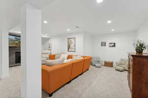 Carpeted living area featuring recessed lighting, a fireplace, and baseboards
