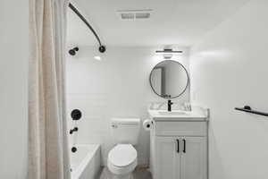 Bathroom featuring toilet, vanity, and shower / tub combo