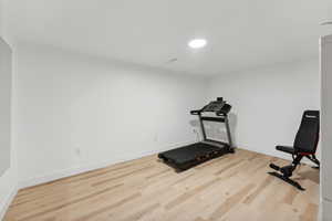Exercise room with wood finished floors and baseboards