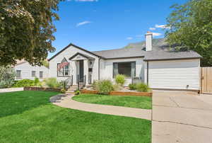 View of front of property with driveway, an attached garage, and a chimney