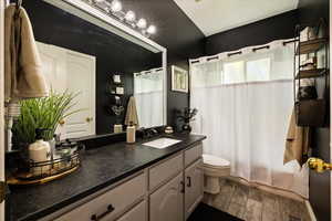Full bath with wood finished floors, toilet, vanity, and a shower with curtain