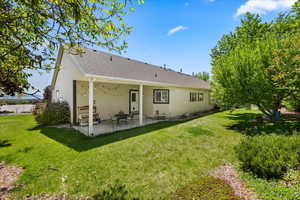 Back of property featuring a patio area, a yard, and stucco siding
