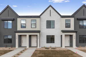 Townhome / multi-family property featuring brick siding and stucco siding