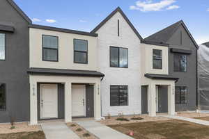 Townhome / multi-family property featuring stucco siding and brick siding