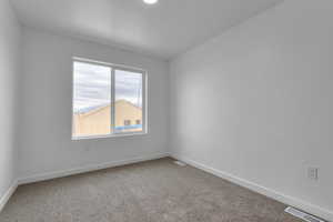 Spare room with carpet and baseboards