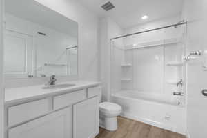 Full bathroom with wood finished floors, toilet, shower / bath combination, and vanity