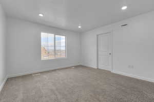 Carpeted spare room with recessed lighting and baseboards