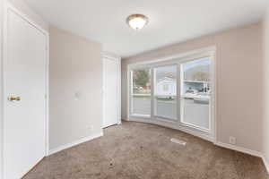 Sun-bathed primary bedroom featuring a large bay window.