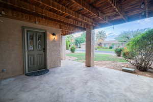 View of exterior entry with stucco siding and a patio