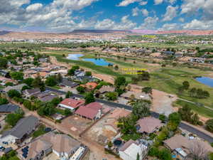 Aerial perspective of suburban area with a water and mountain view and a local golf course