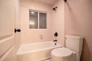 Full bathroom featuring toilet and shower / washtub combination