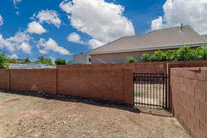 View of yard featuring fence and a gate