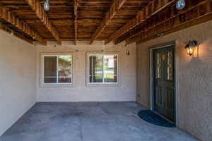 View of exterior entry with stucco siding and a patio